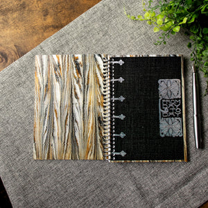 A travel-sized spiral notebook featuring a vintage book cover: FromDay To Day. Features a bold floral design. The colors are black, silver, gold and brown.